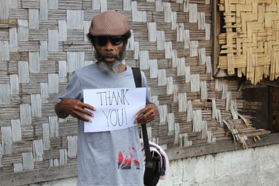 Man holding a hand written sign saying "Thank You":